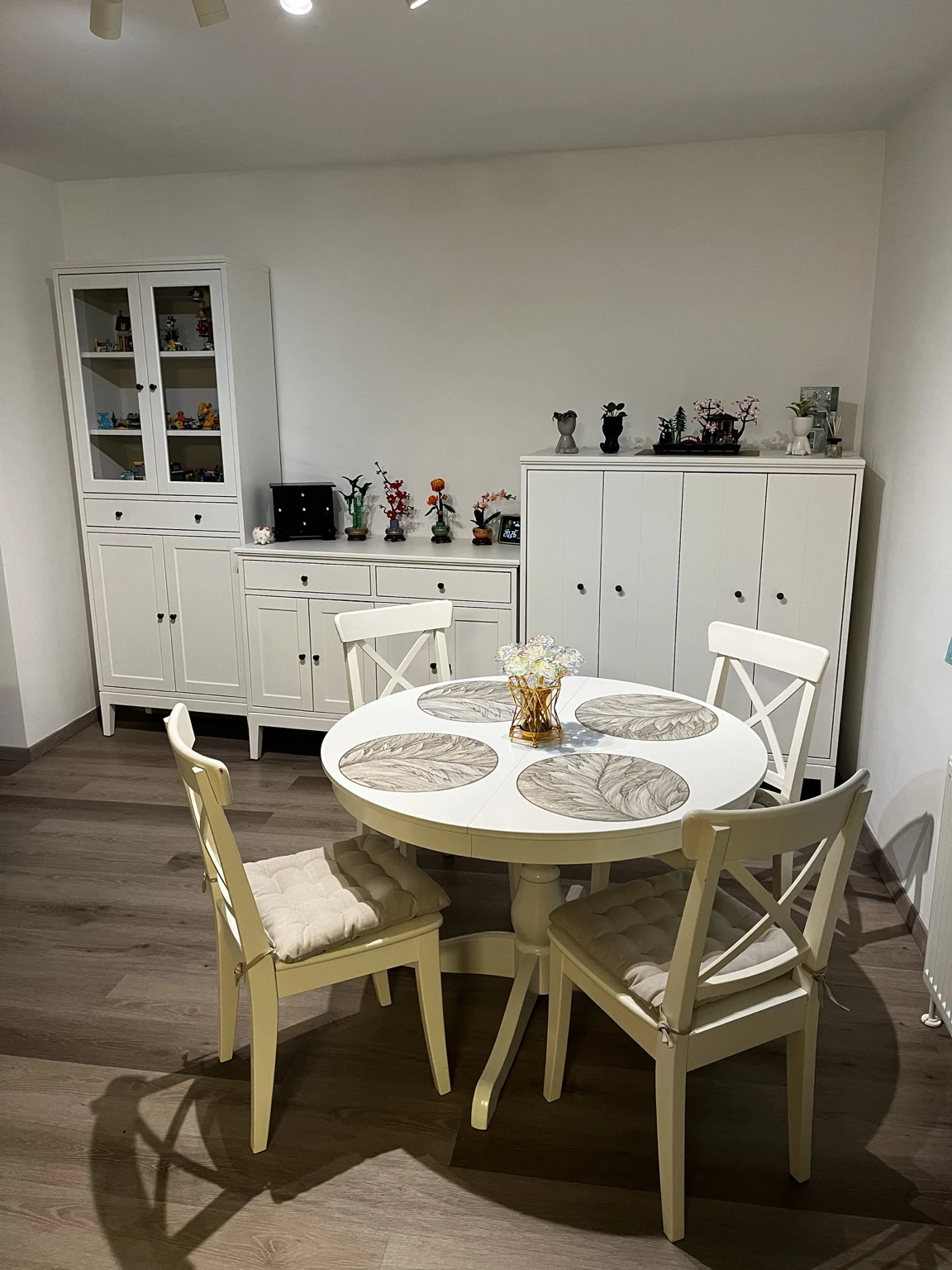 Weiße Esszimmermöbel mit rundem Tisch und vier Stühlen